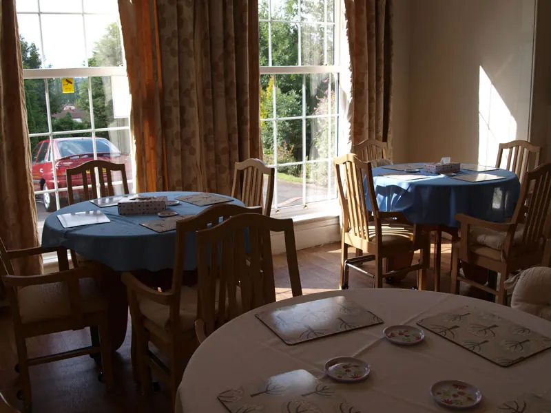 Dining room with round tables by a tall window