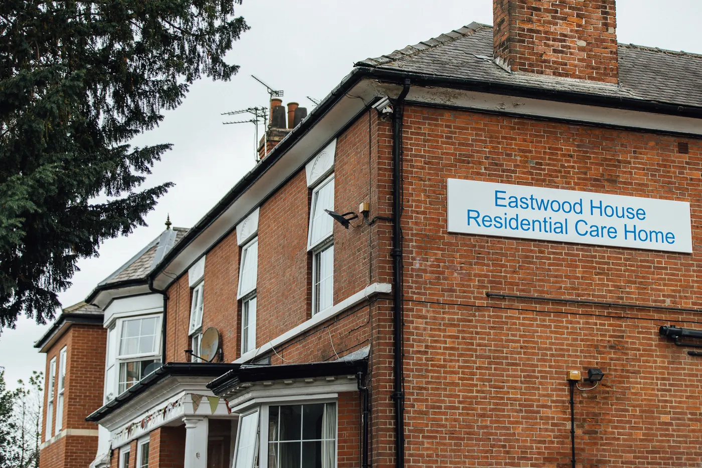 The red-brick front of Eastwood House, with the Eastwood House Residential Care Home sign